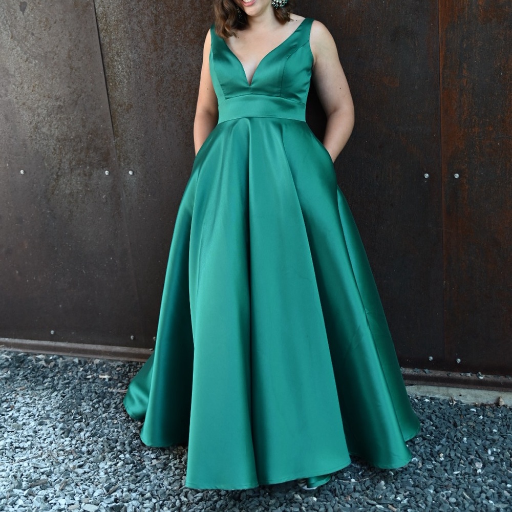 Emerald green formal gown with low back, plunging neckline and pockets
